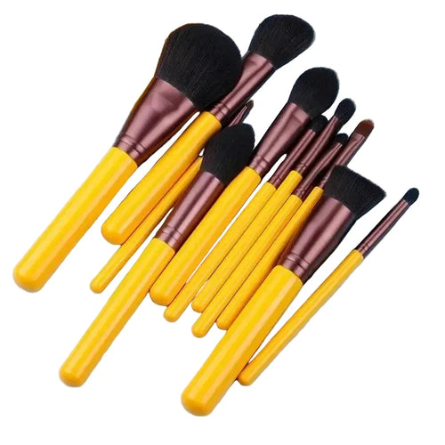 Set of makeup brushes with yellow handles and brown ferrules on a light blue background