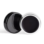 Black cosmetic cream in a round container with a black lid on a white background