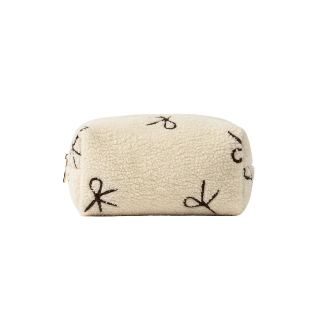 Beige pouch with embroidered designs on a dark surface