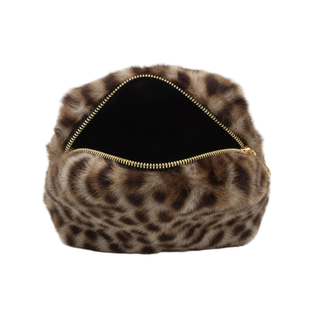 Close-up of a fur-lined pouch with a gold zipper on a marble surface