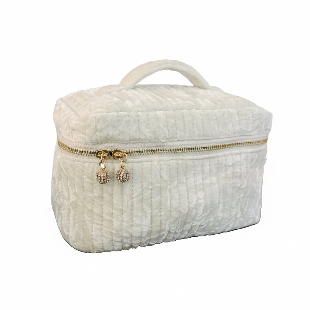 White textured makeup bag with gold zipper on a marble surface