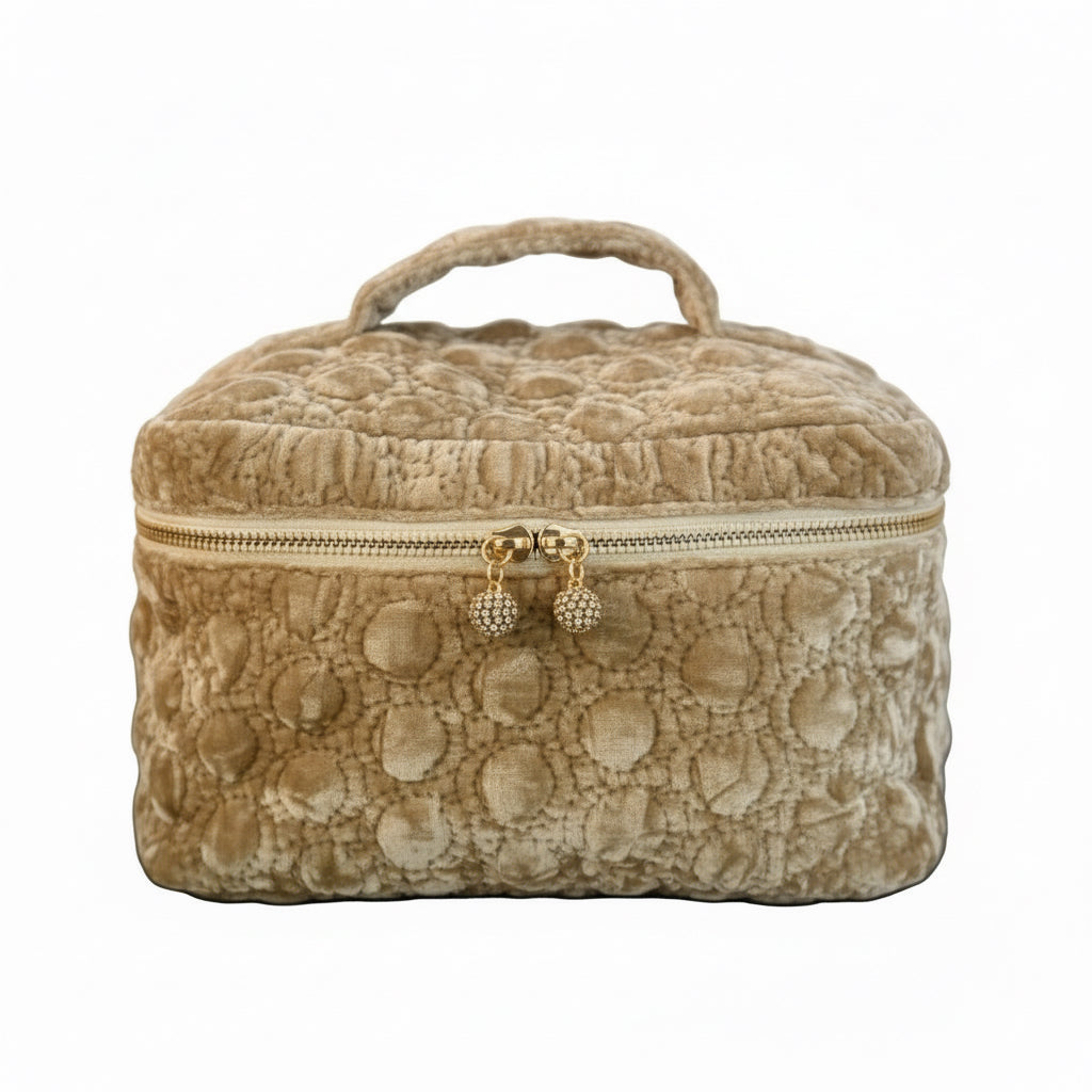 Beige textured jewelry box with gold zipper on a dark surface