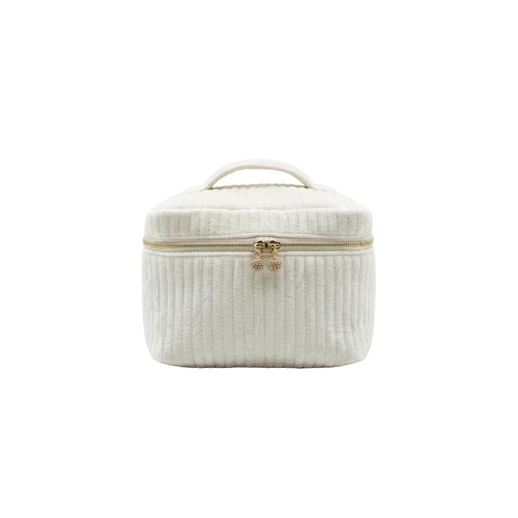 Two cream-colored textured bags with gold zippers on a dark surface.