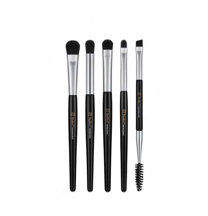 Set of makeup brushes with black handles and silver ferrules, next to their packaging.