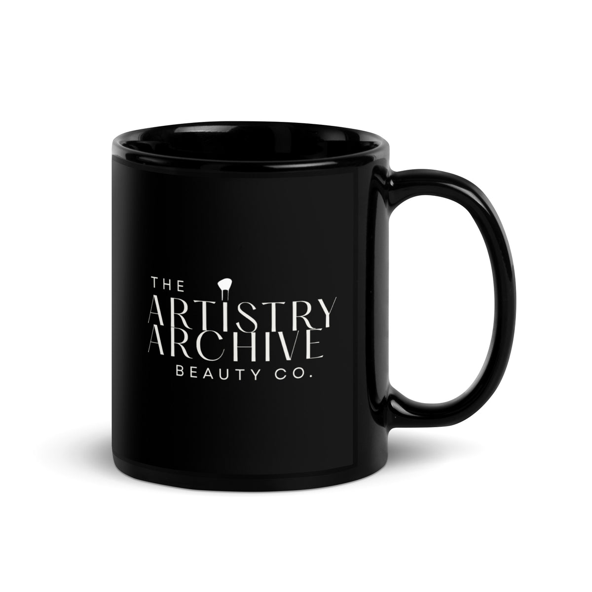 A glossy black ceramic mug with a white printed logo reading 'THE ARTISTRY ARCHIVE BEAUTY CO.' on the front, shown on a clean white background.