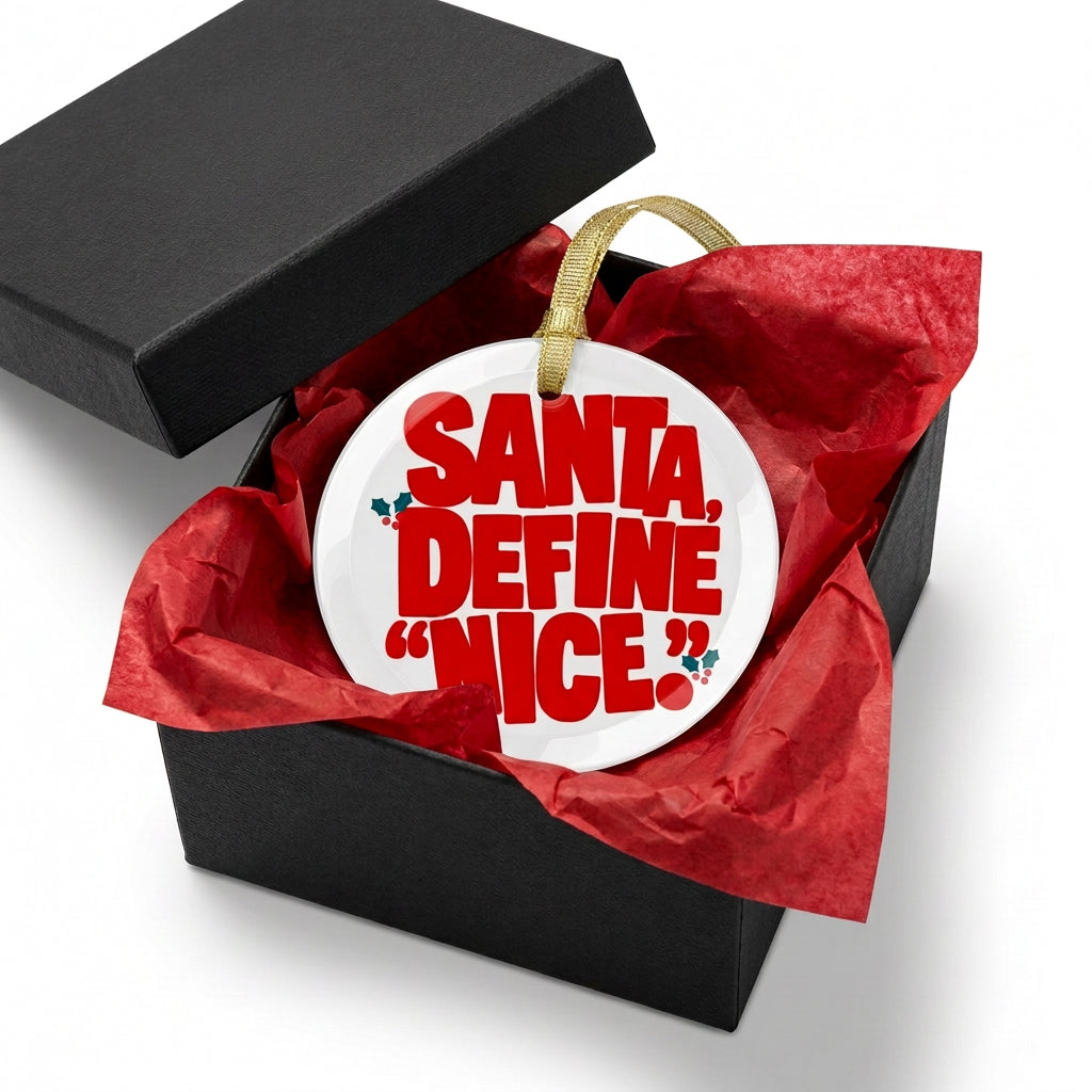 A round white Christmas ornament with bold red text reading 'SANTA, DEFINE "NICE"' and small holly accents, hanging from a gold ribbon on a white background.