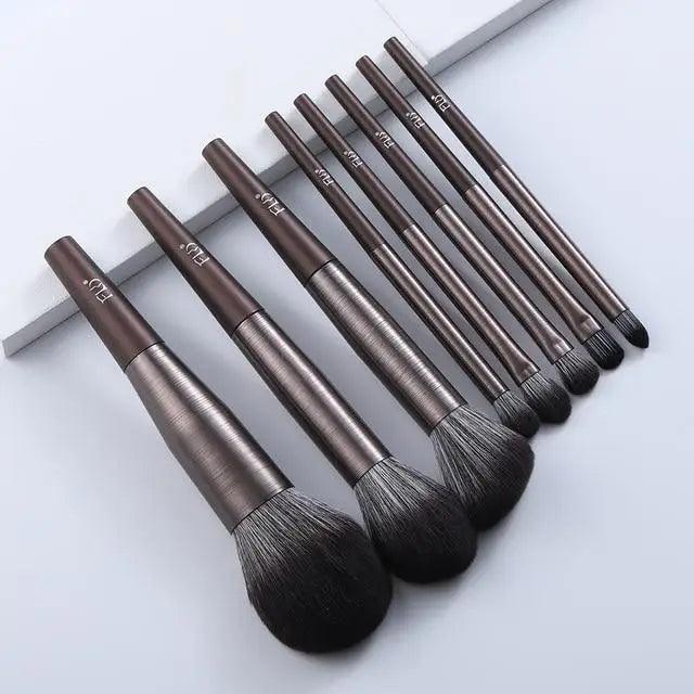 Set of makeup brushes with brown handles on a white background