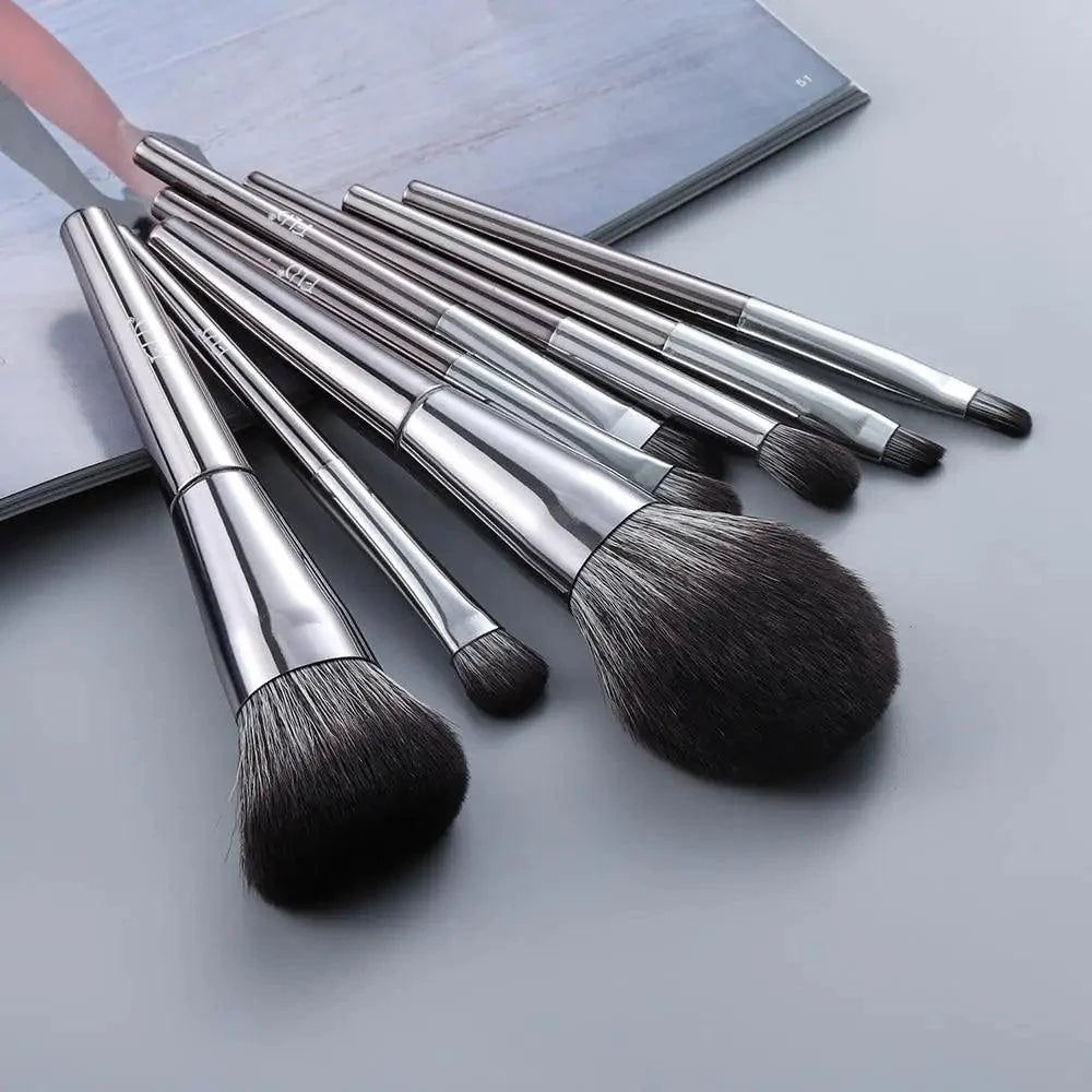 Set of makeup brushes with silver handles on a light gray background
