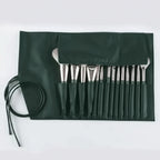 Set of paintbrushes in a green case on a white background