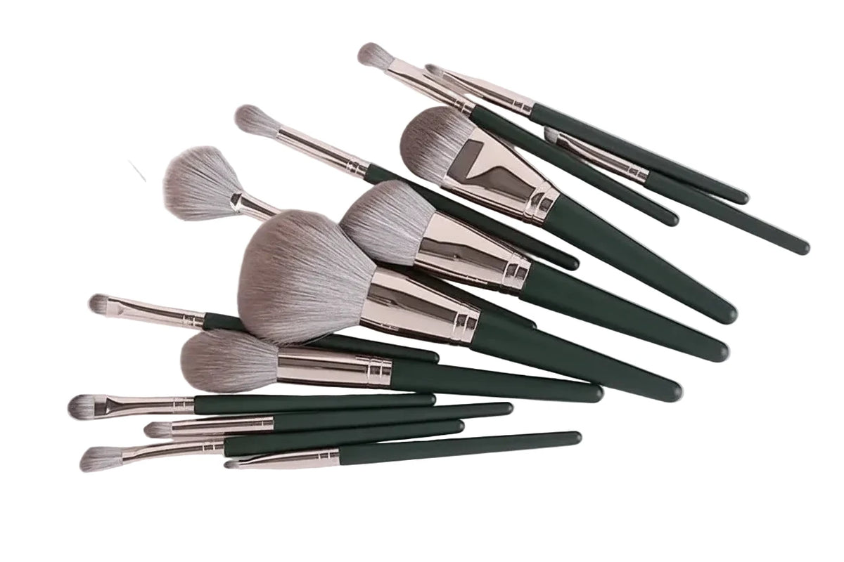 A 15-piece makeup brush set with dark green handles, silver ferrules, and light gray bristles, arranged on a plain white background.