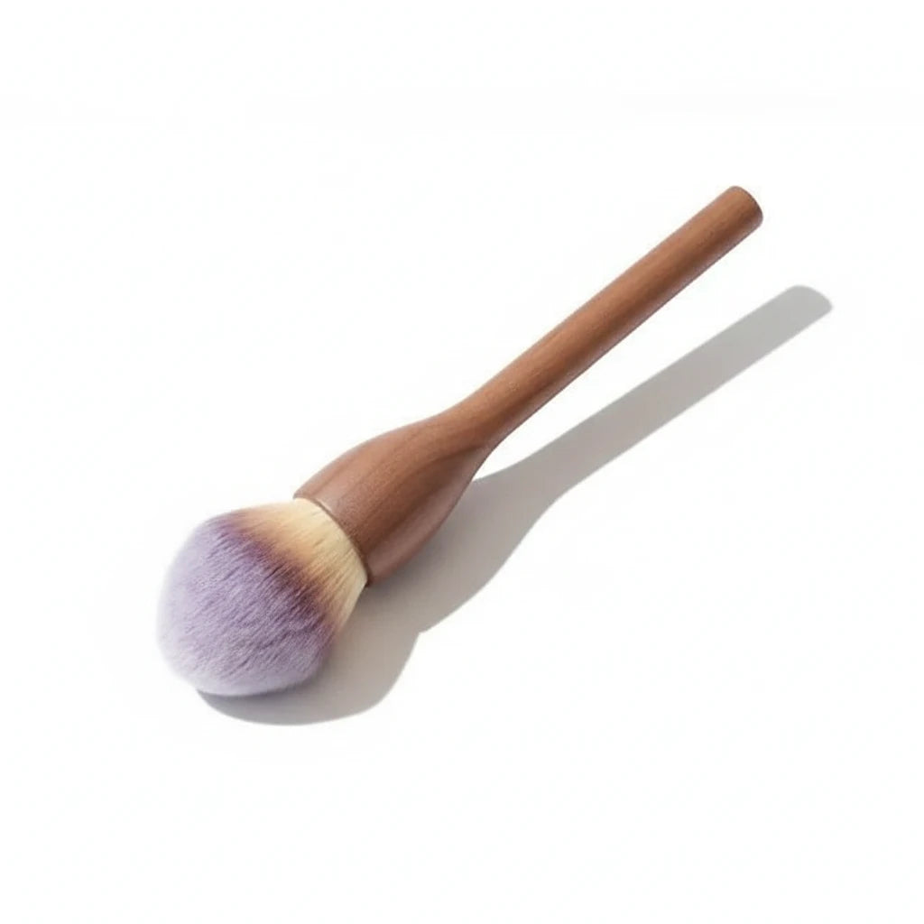 Makeup brush with wooden handle and purple bristle head on a light gray background