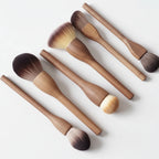 Set of wooden makeup brushes on a light gray background